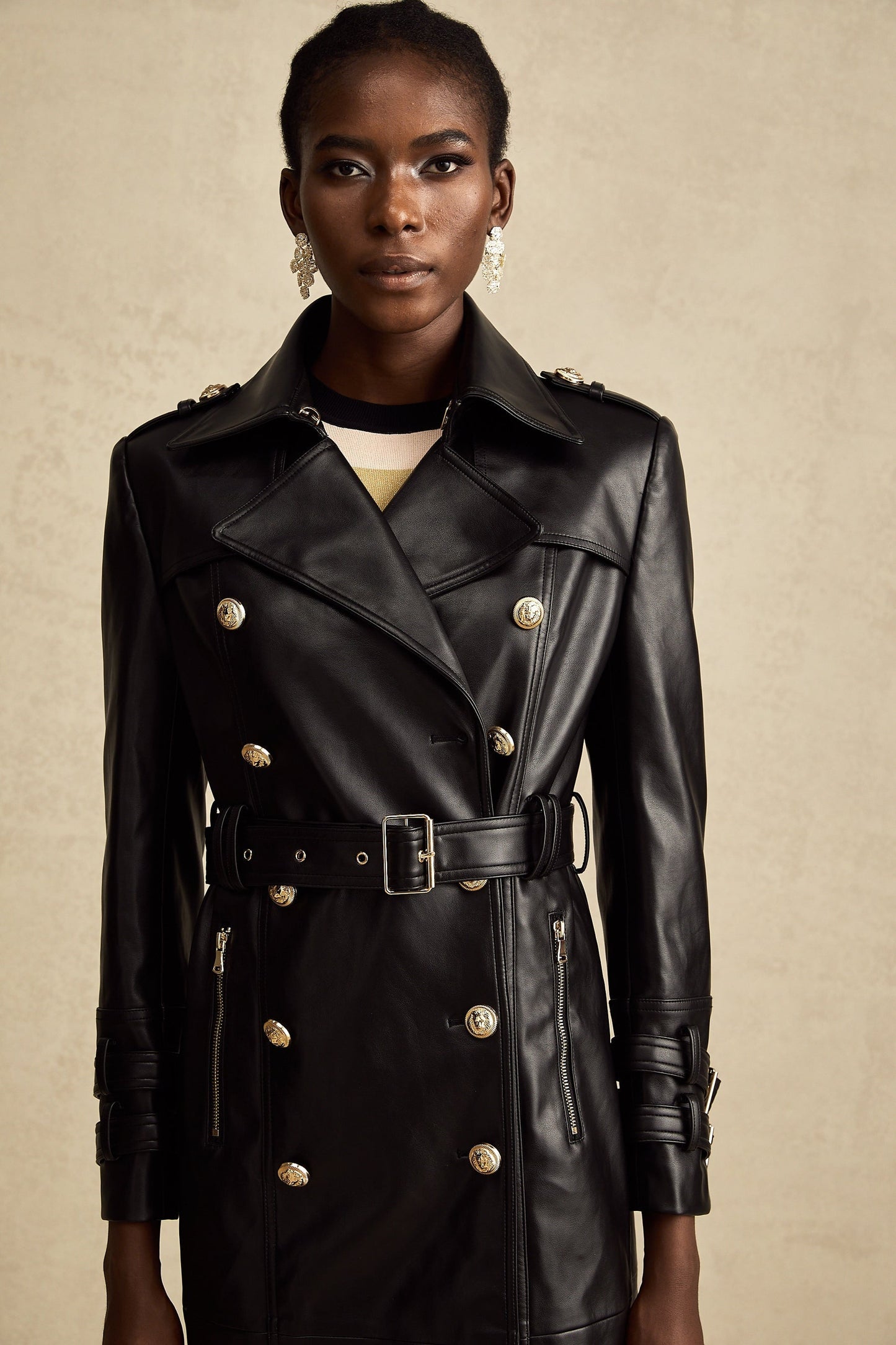 black doublebreasted leather coat with a belt cinched at the waist