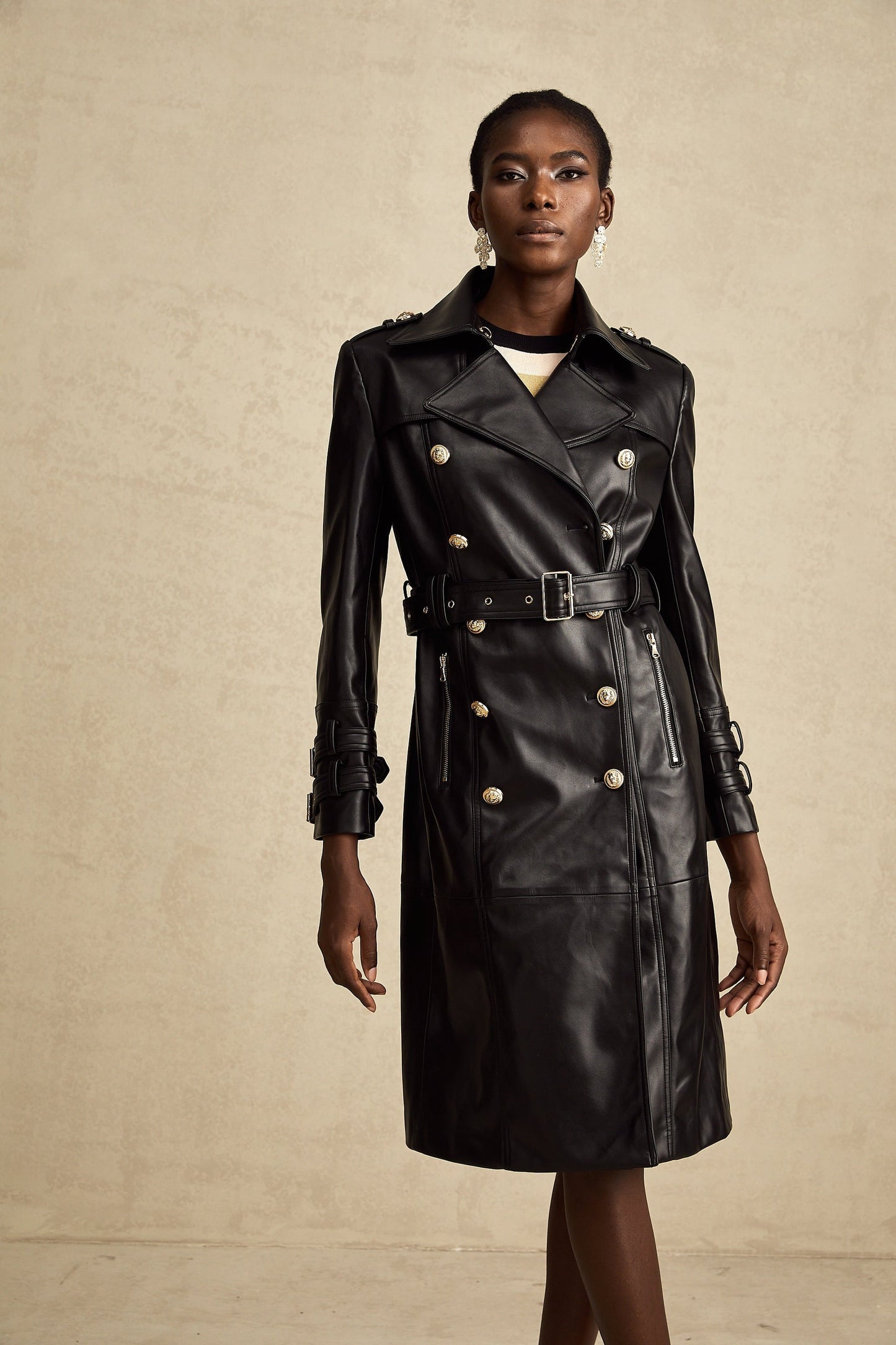 black doublebreasted leather coat with a belt cinched at the waist