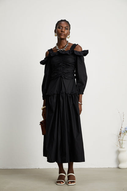 A black pleated midi dress with ruffled details and a flowy silhouette