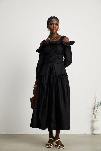 A black pleated midi dress with ruffled details and a flowy silhouette