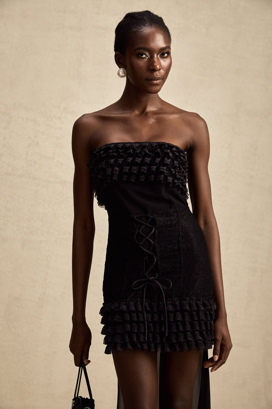 A black mini dress with ruffled details and a train design