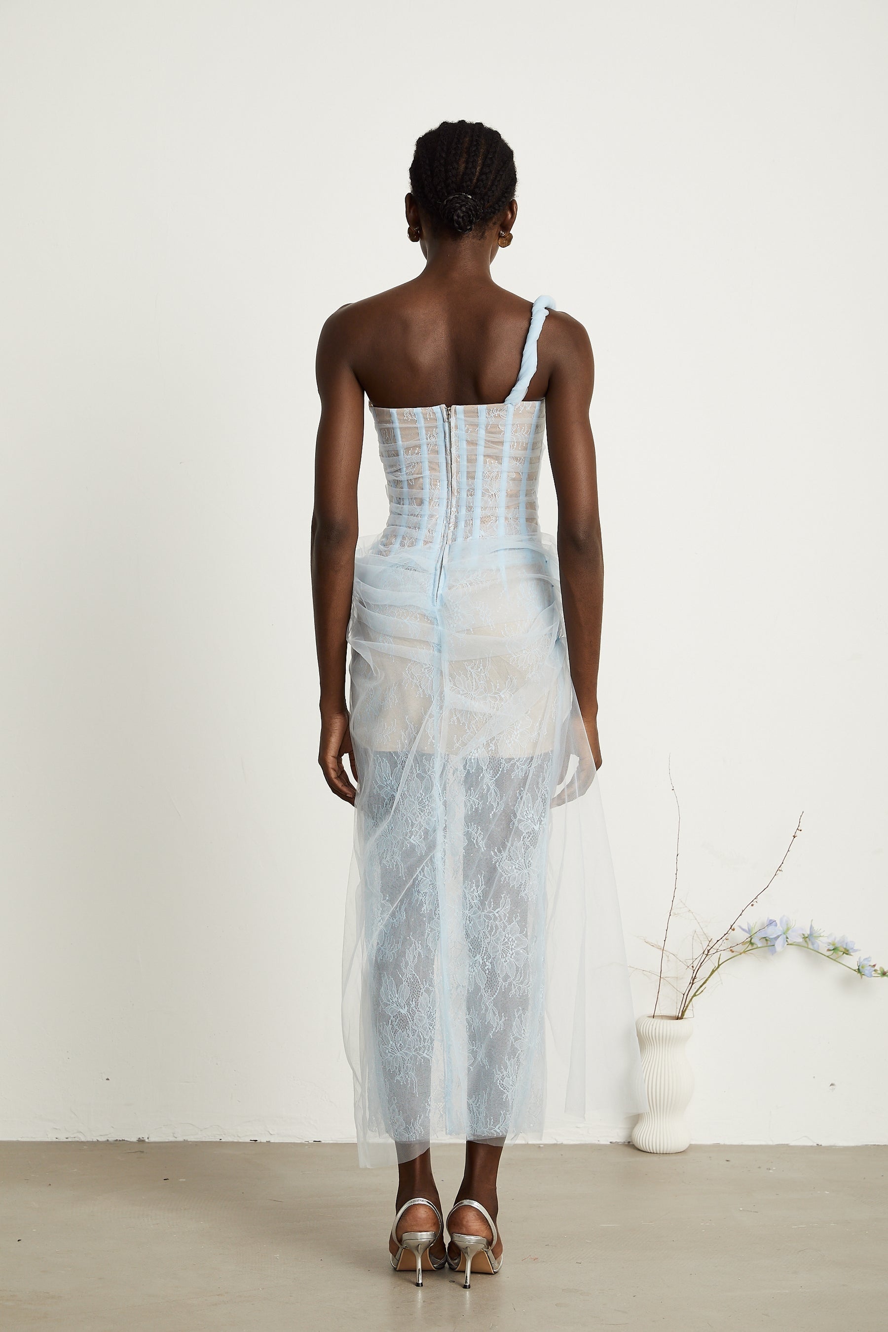 A blue pleated midi dress with mesh fabric featuring a flowing silhouette and delicate texture