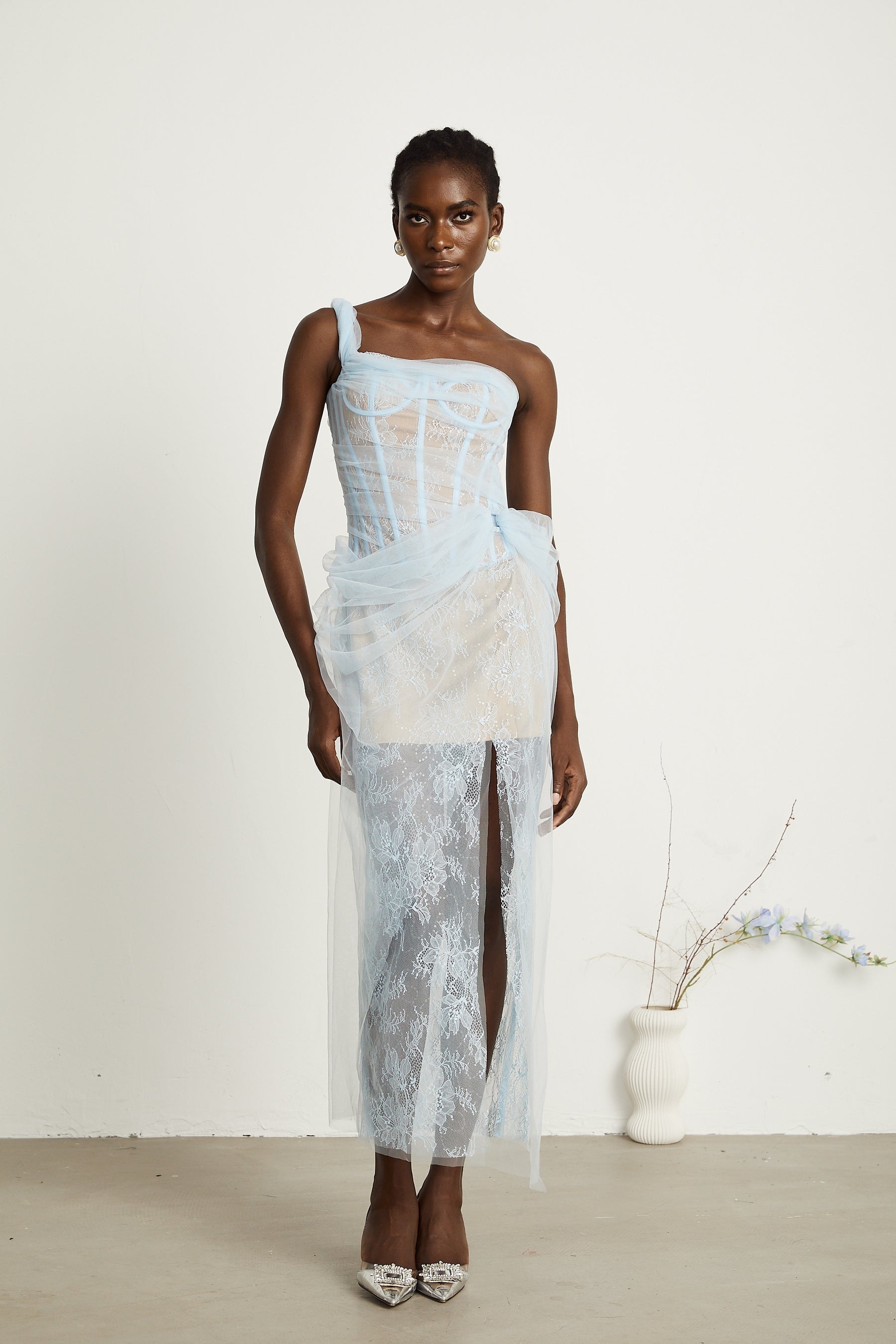 A blue pleated midi dress with mesh fabric featuring a flowing silhouette and delicate texture