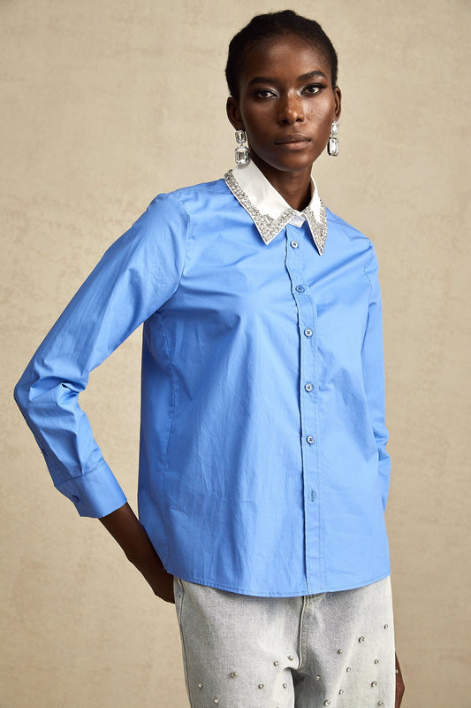 A blue shirt with rhinestone embellishments and color block design