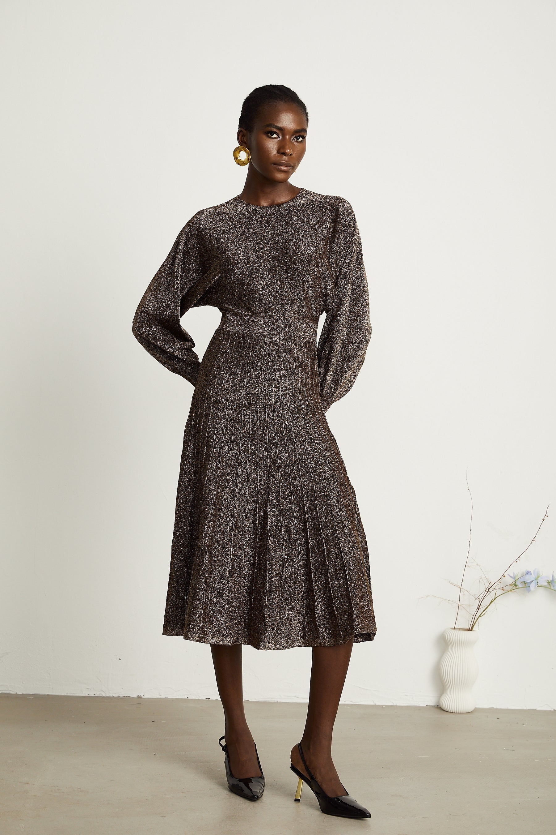 A brown ribbed midi dress with metallic threading and a fitted silhouette