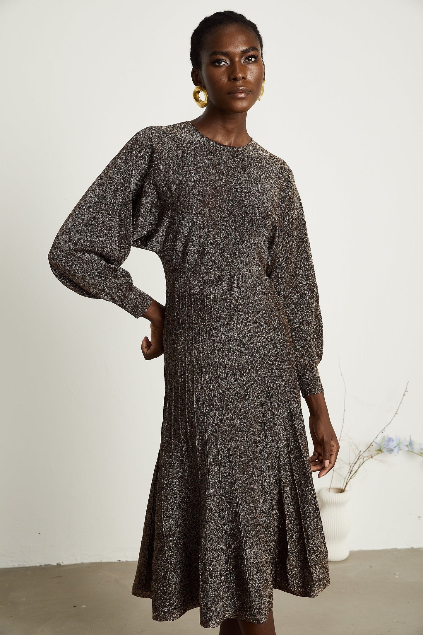 A brown ribbed midi dress with metallic threading and a fitted silhouette