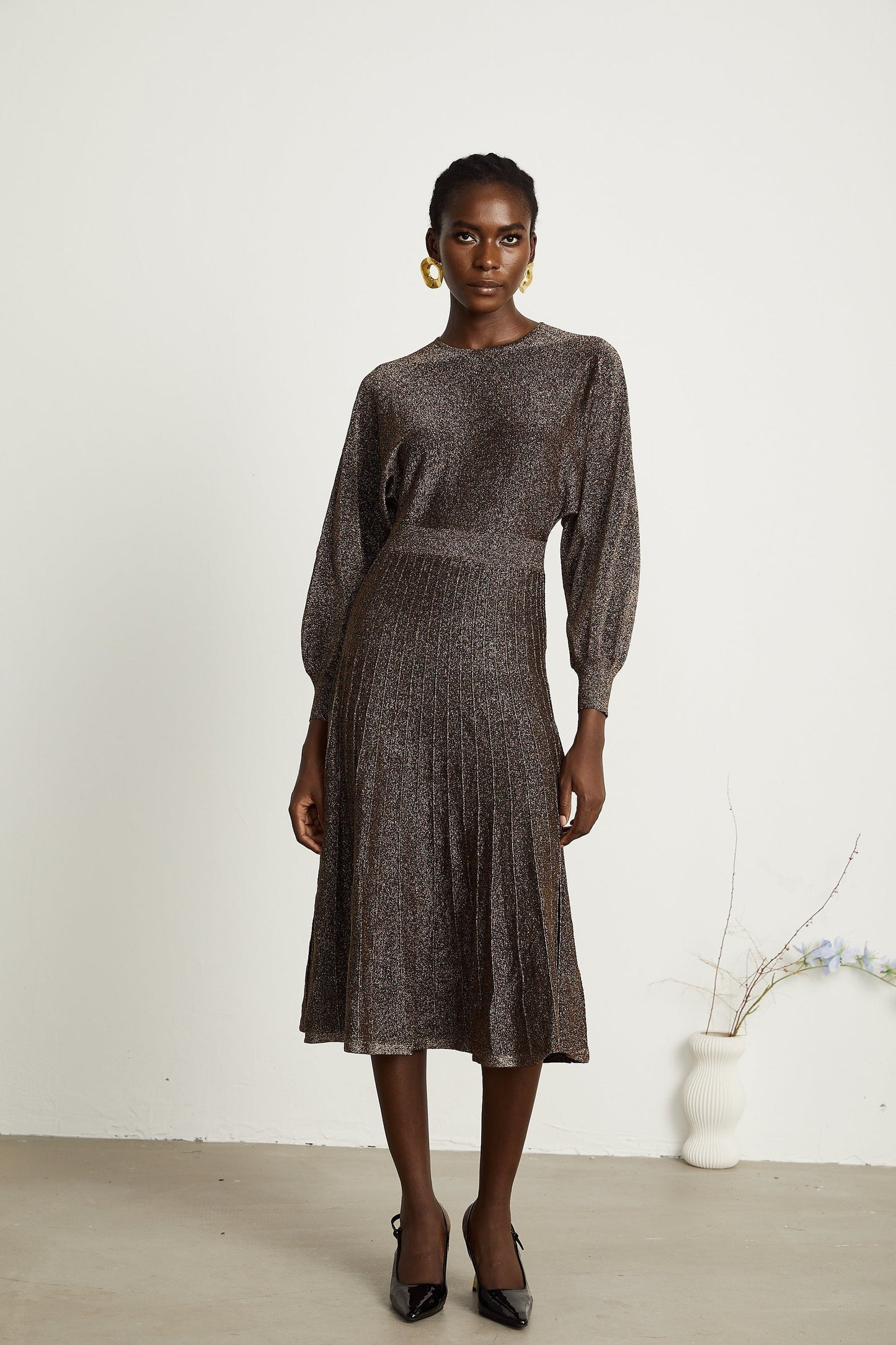 A brown ribbed midi dress with metallic threading and a fitted silhouette