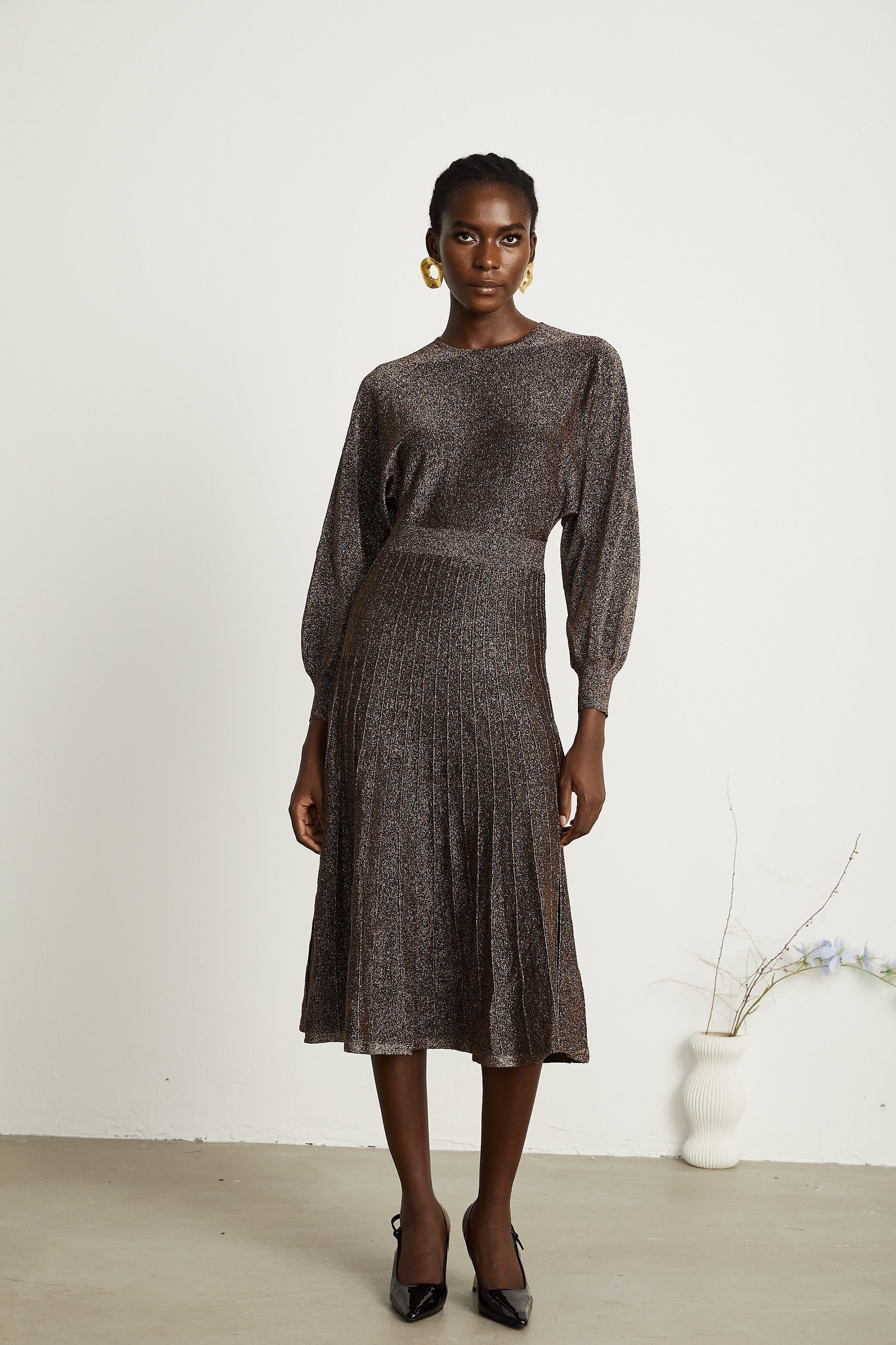 A brown ribbed midi dress with metallic threading and a fitted silhouette