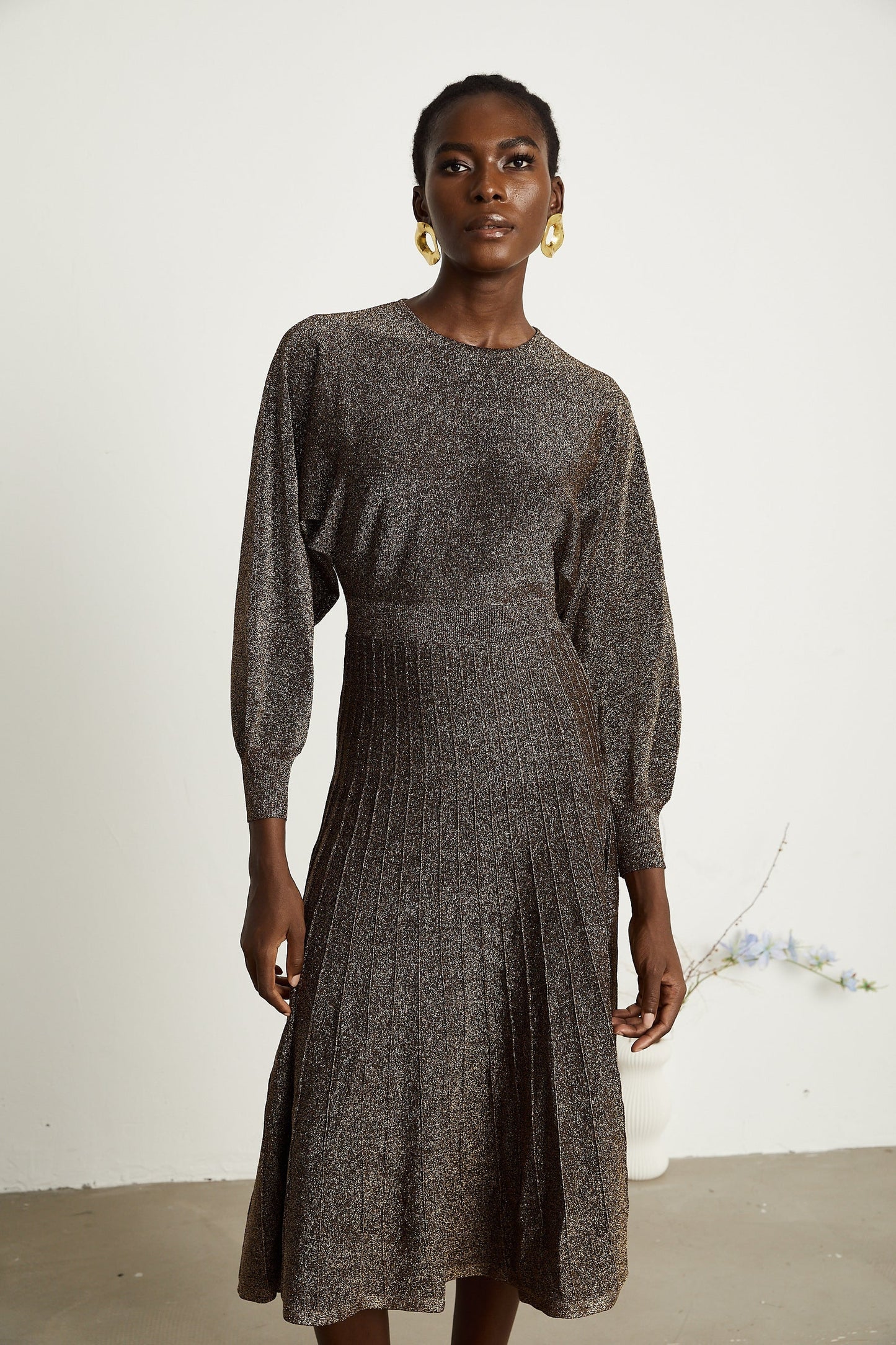 A brown ribbed midi dress with metallic threading and a fitted silhouette