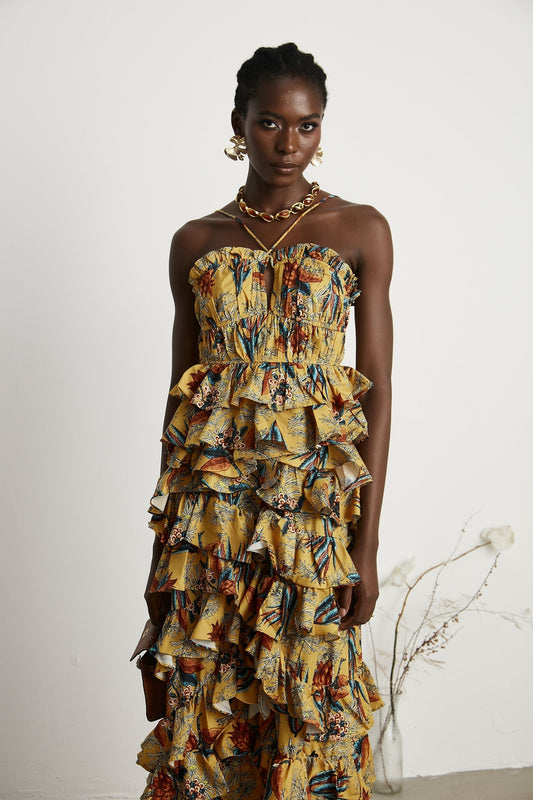 A floral printed midi dress with tiered ruffles named Apolline featuring a layered skirt and feminine silhouette