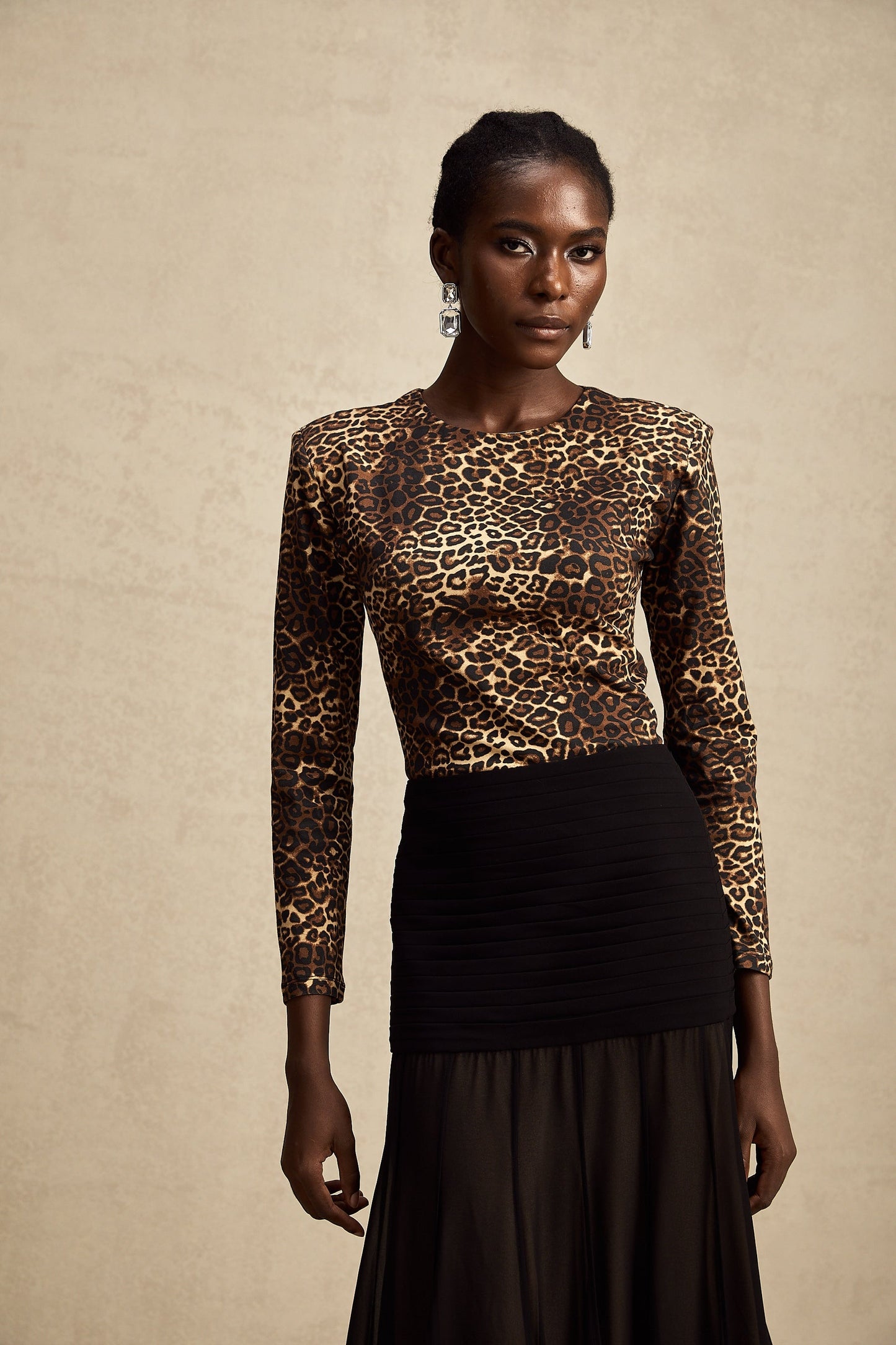 A leopard print bodysuit with long sleeves and a high neckline