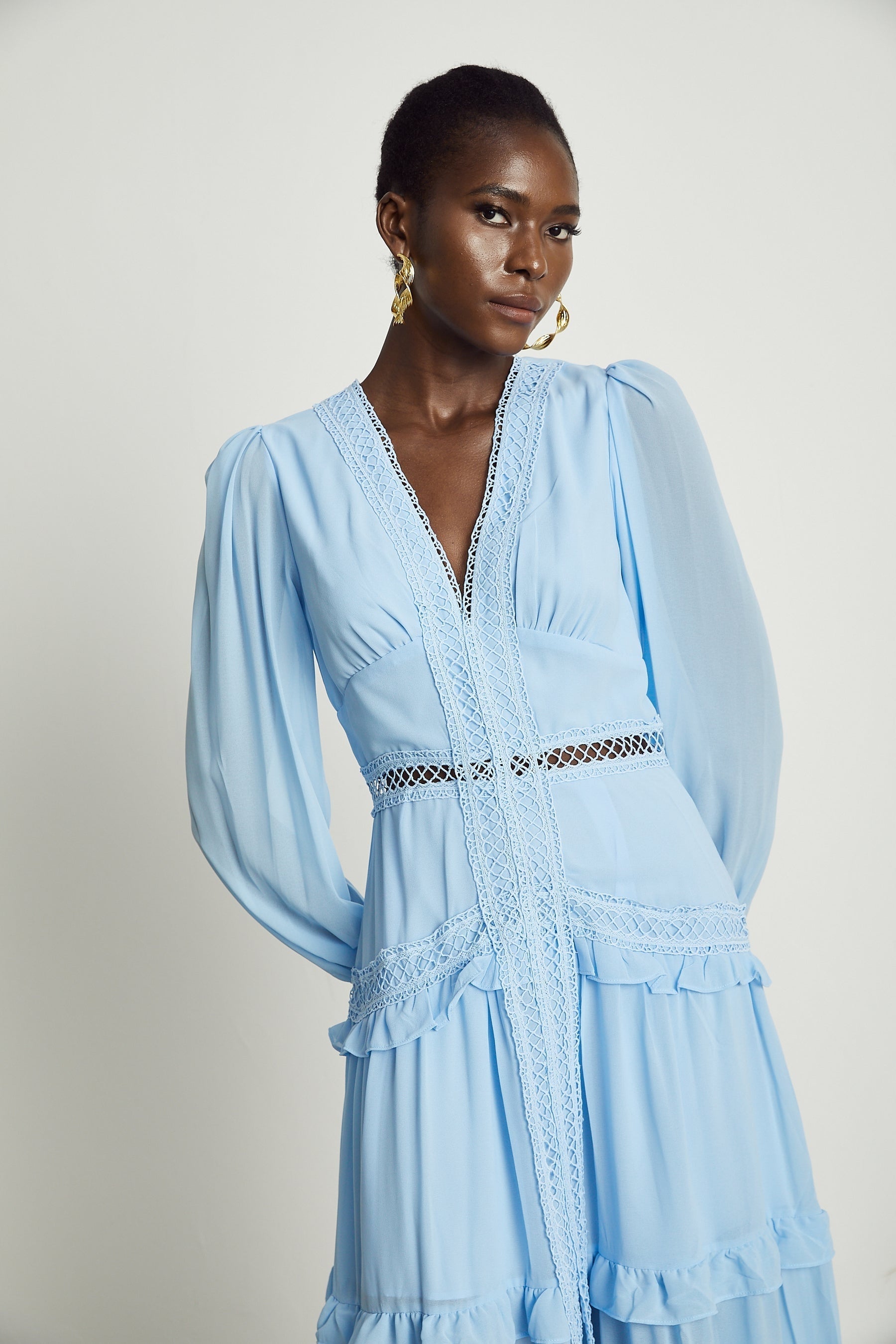 A long blue maxi dress with ruffle details and cutout sections