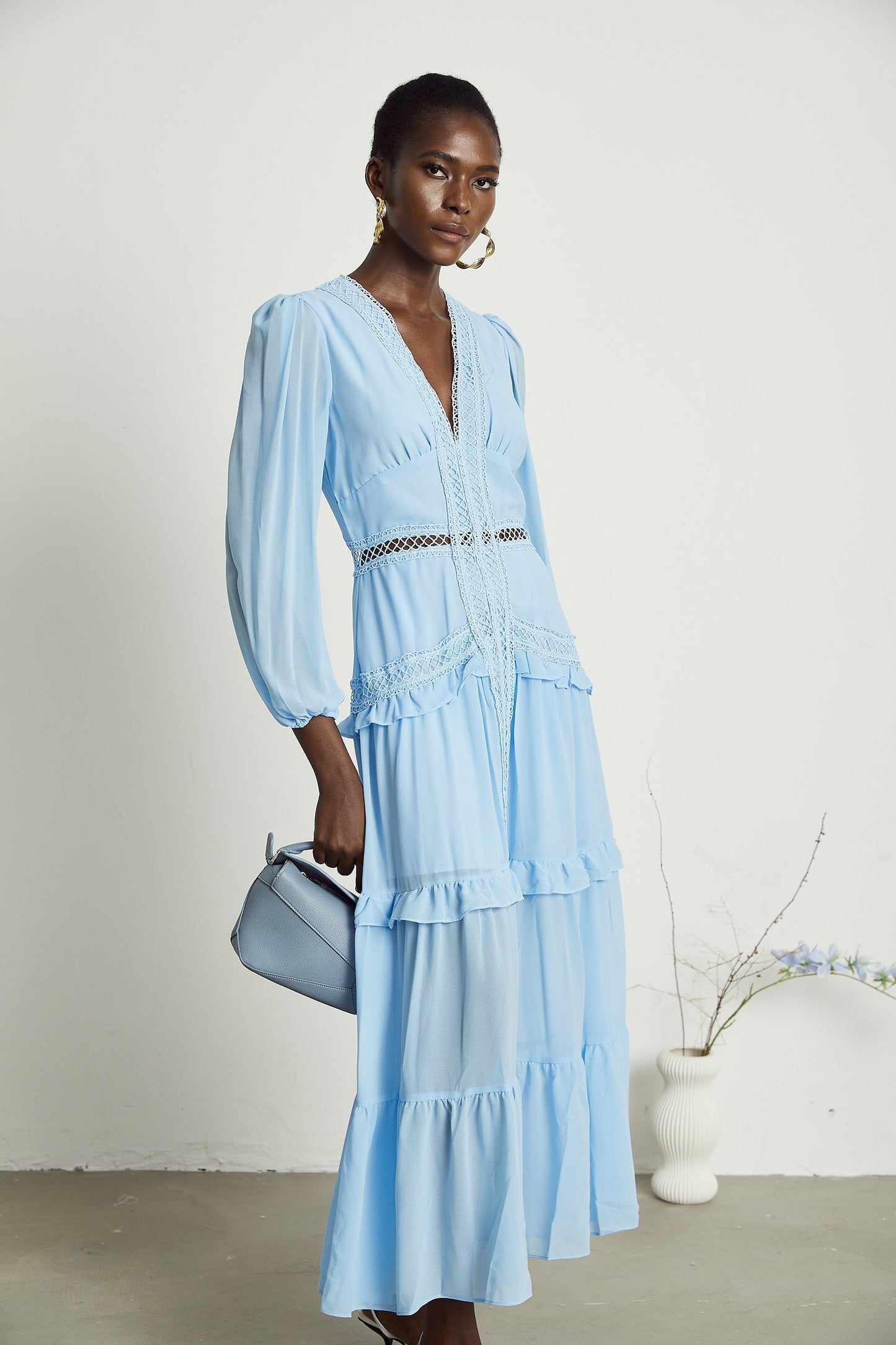 A blue maxi dress with ruffles and cutout details featuring a long flowing skirt and feminine silhouette