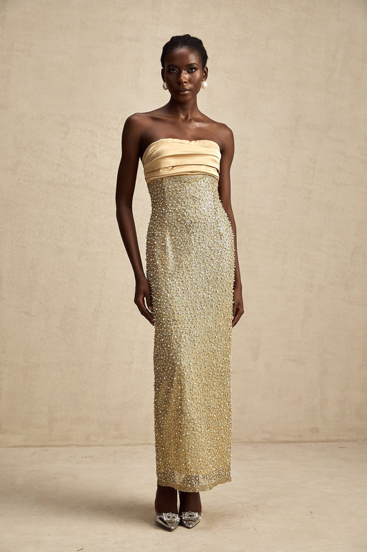 A long gold maxi dress adorned with faux pearl embellishments featuring a floral design named Marguerite