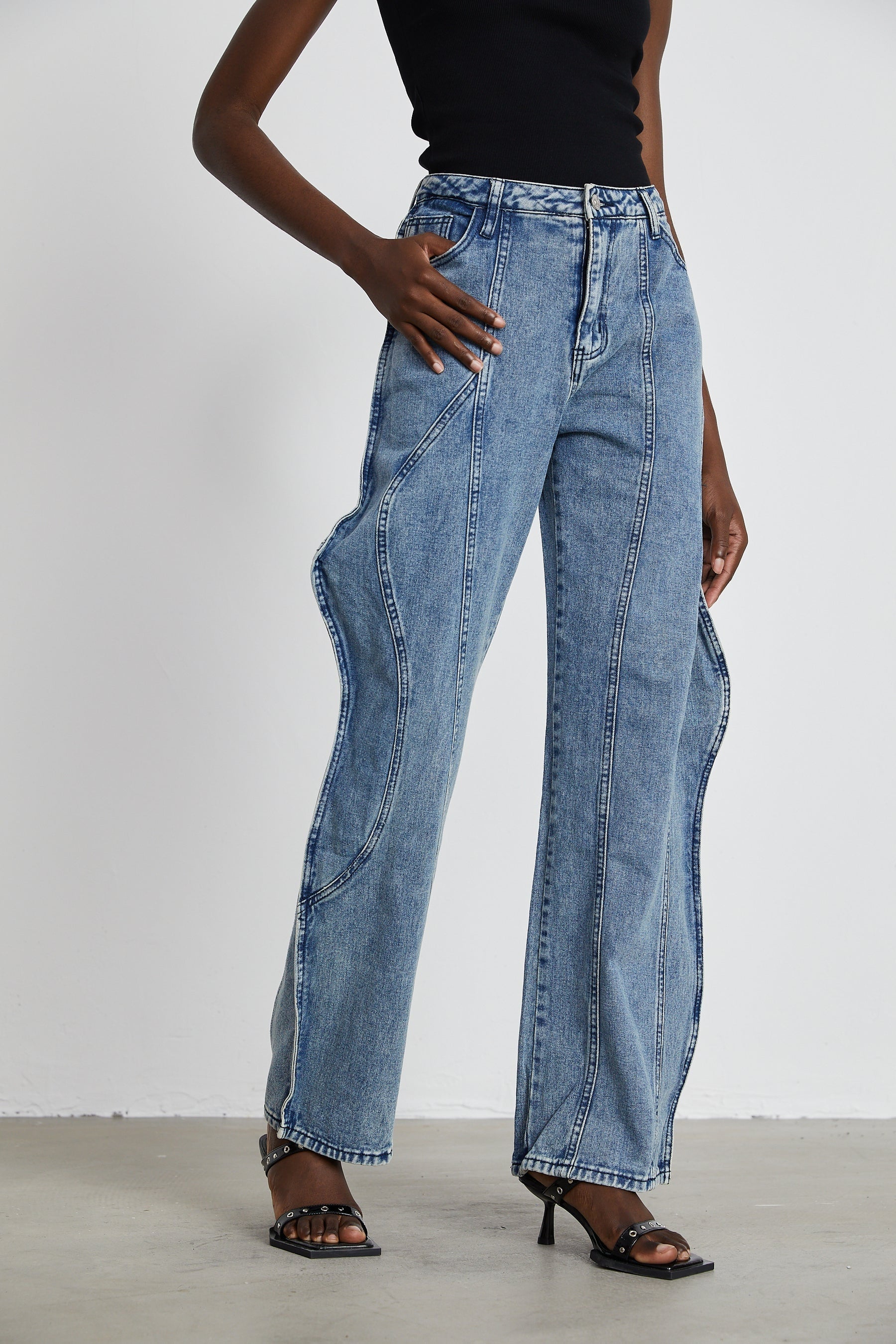 A pair of jeans with an asymmetric design and wide legs called Brigitte featuring a unique silhouette and modern cut