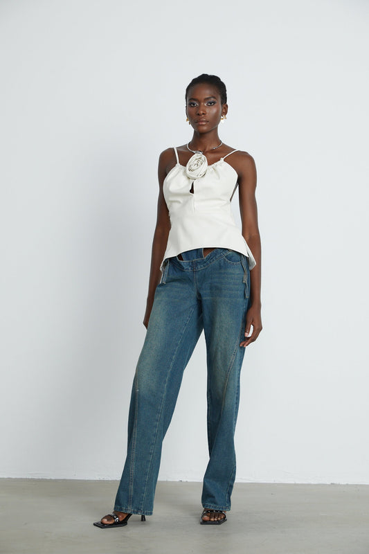 A pair of light blue denim jeans with cutout details and tie fastenings visible on the sides