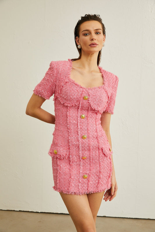 A pink mini dress with a bustier top and frayed edges featuring a fitted silhouette