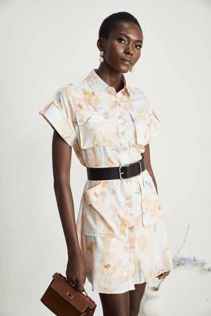 A short black mini dress with a collared shirt style top and a fabric belt tied at the waist