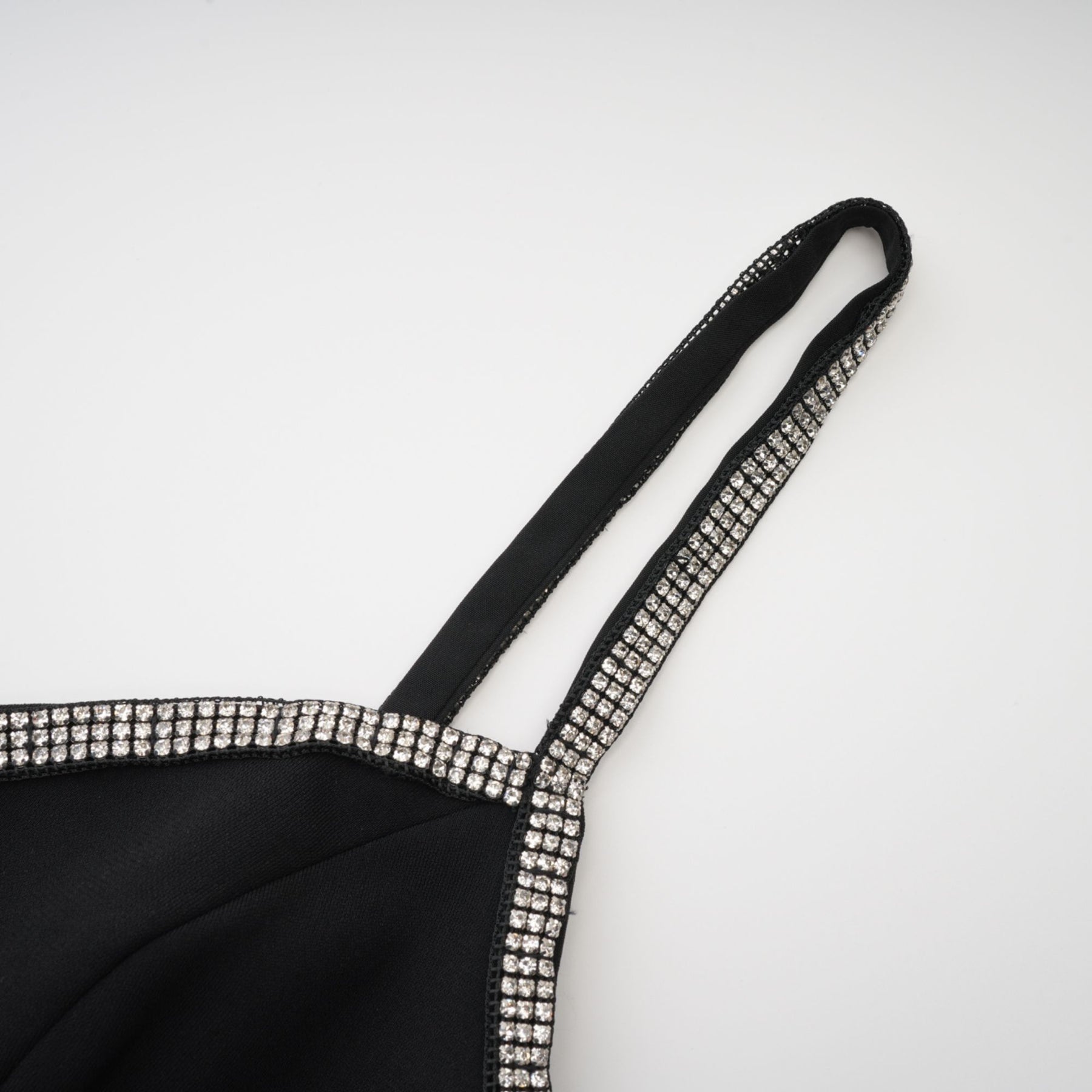 Thighlength black dress with V neckline spaghetti straps bow detailing crystal embellishment feathertrim detailing and rear zip fastening Composed of 100% Polyester