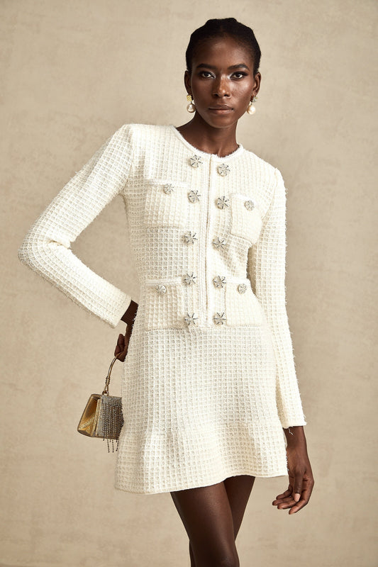 A white knitted mini dress with a flared skirt and short sleeves