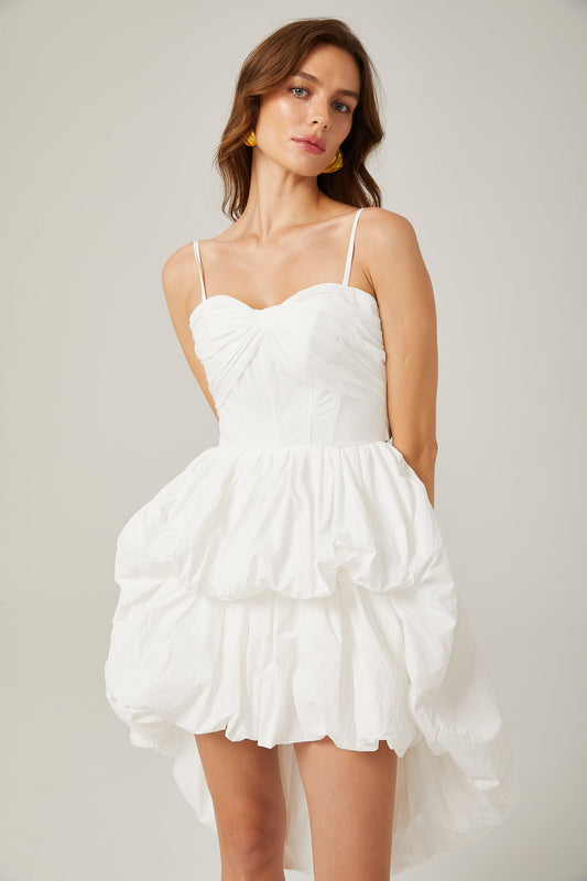 A white mini dress by Chloé featuring a highlow hemline with a shorter front and longer back