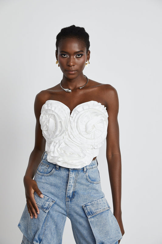 A white sleeveless top with floral appliqué details featuring a design by Yvonne