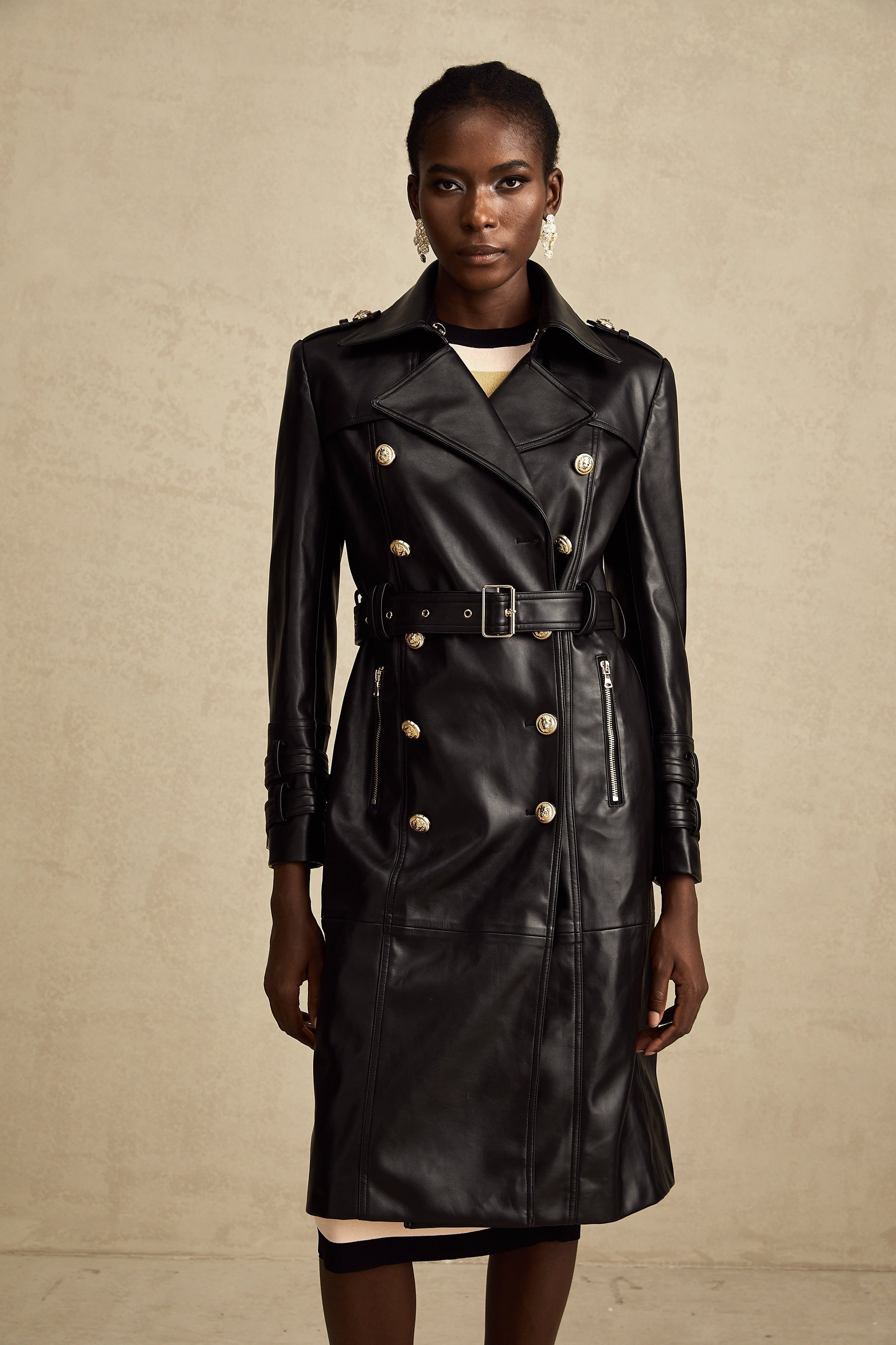 black doublebreasted leather coat with a belt cinched at the waist