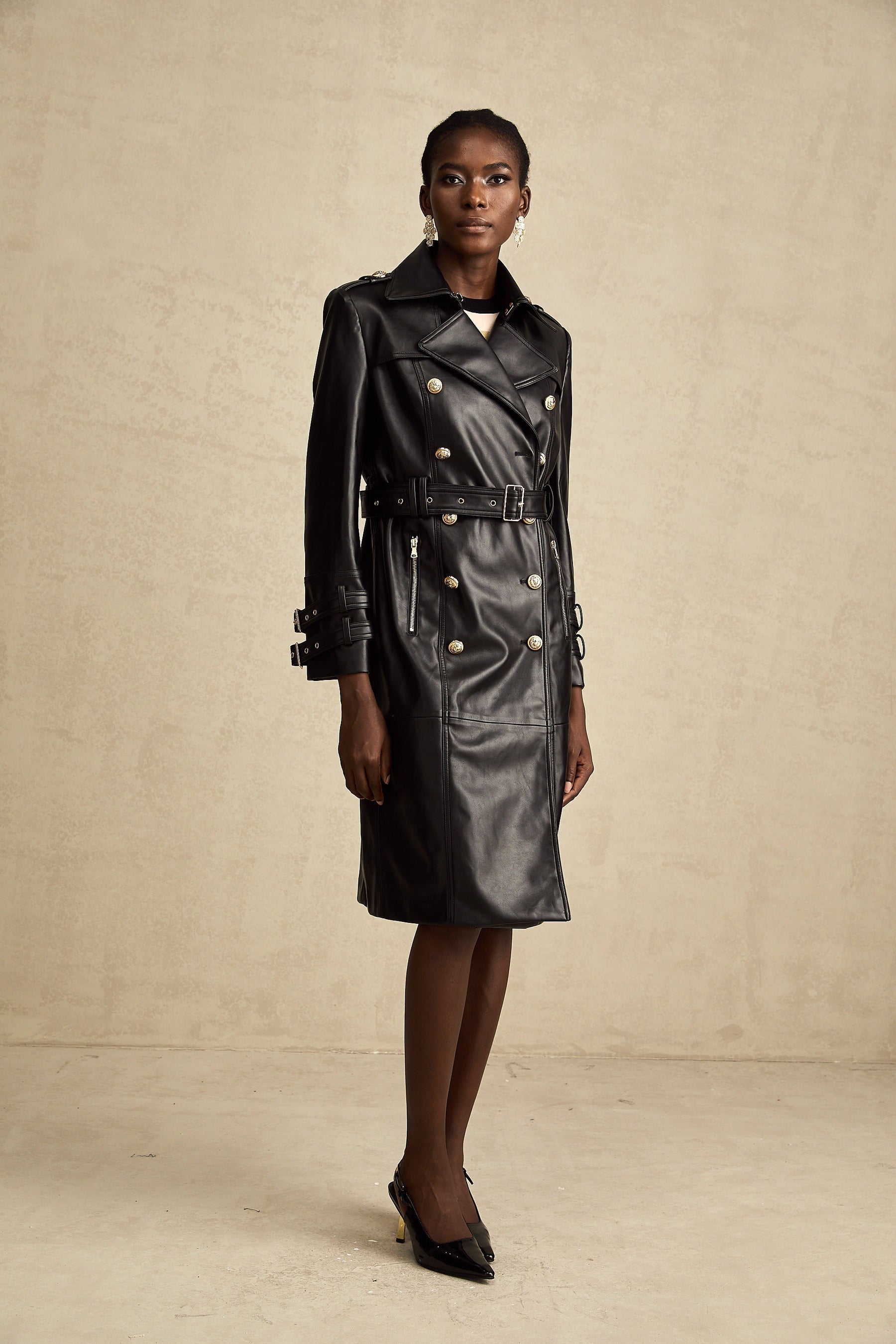 black doublebreasted leather coat with a belt cinched at the waist