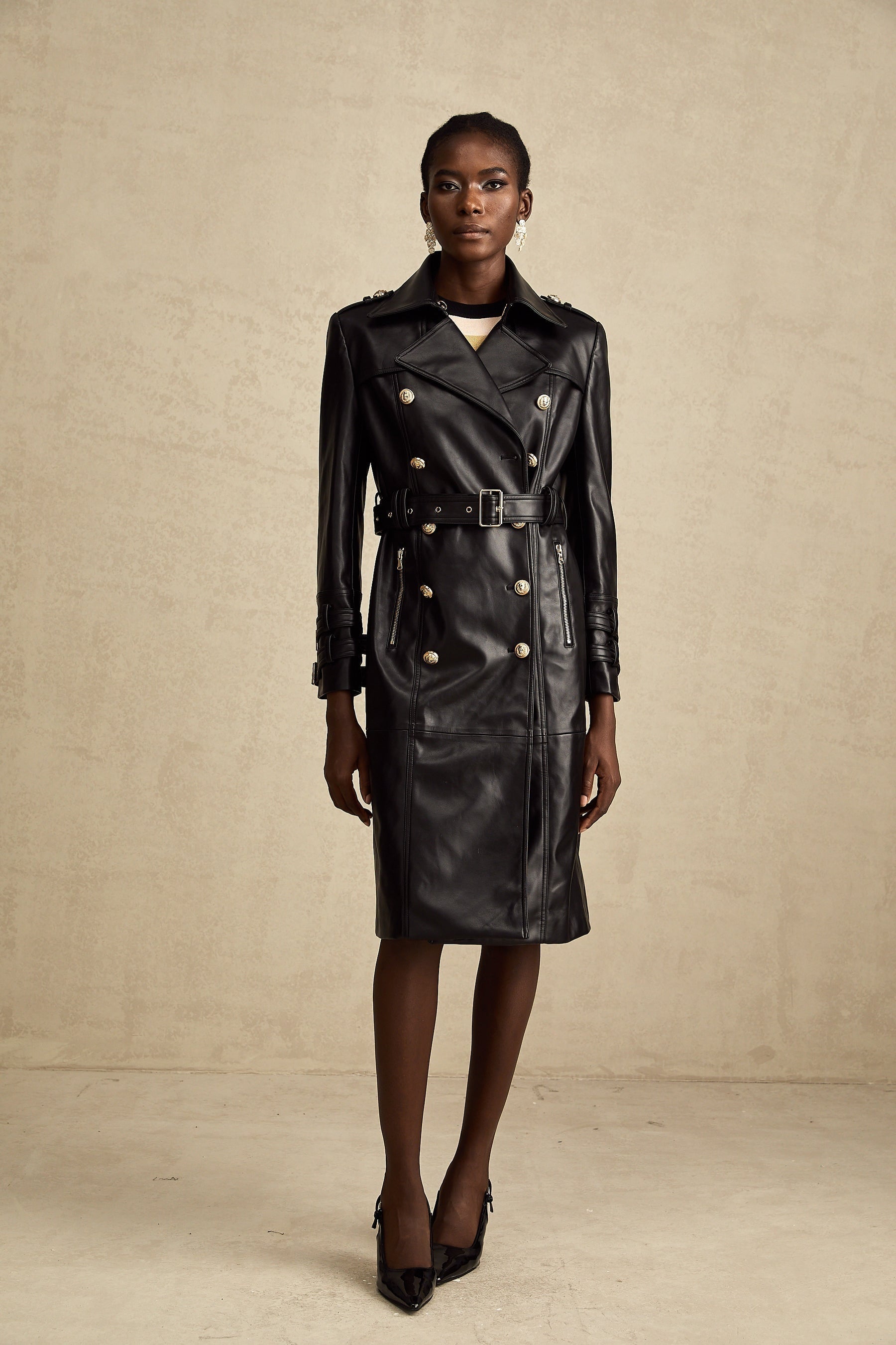 black doublebreasted leather coat with a belt cinched at the waist