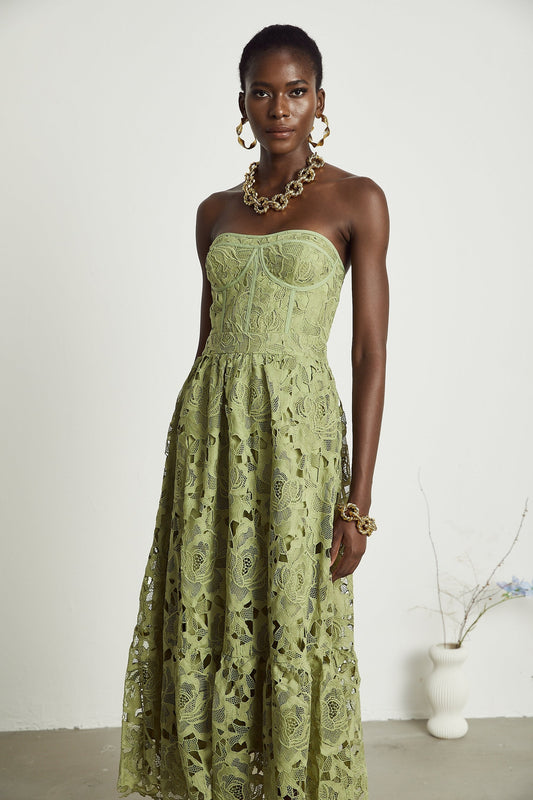 A woman wearing a white midi dress with floral lace embroidery and cutout details