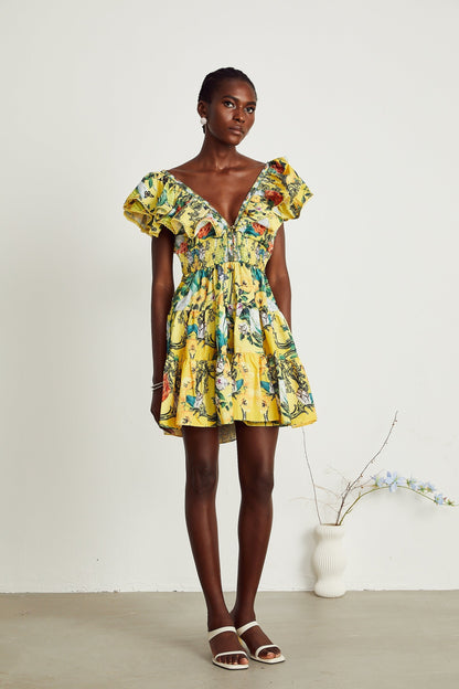 A yellow mini dress with a floral print pattern and ruffled details