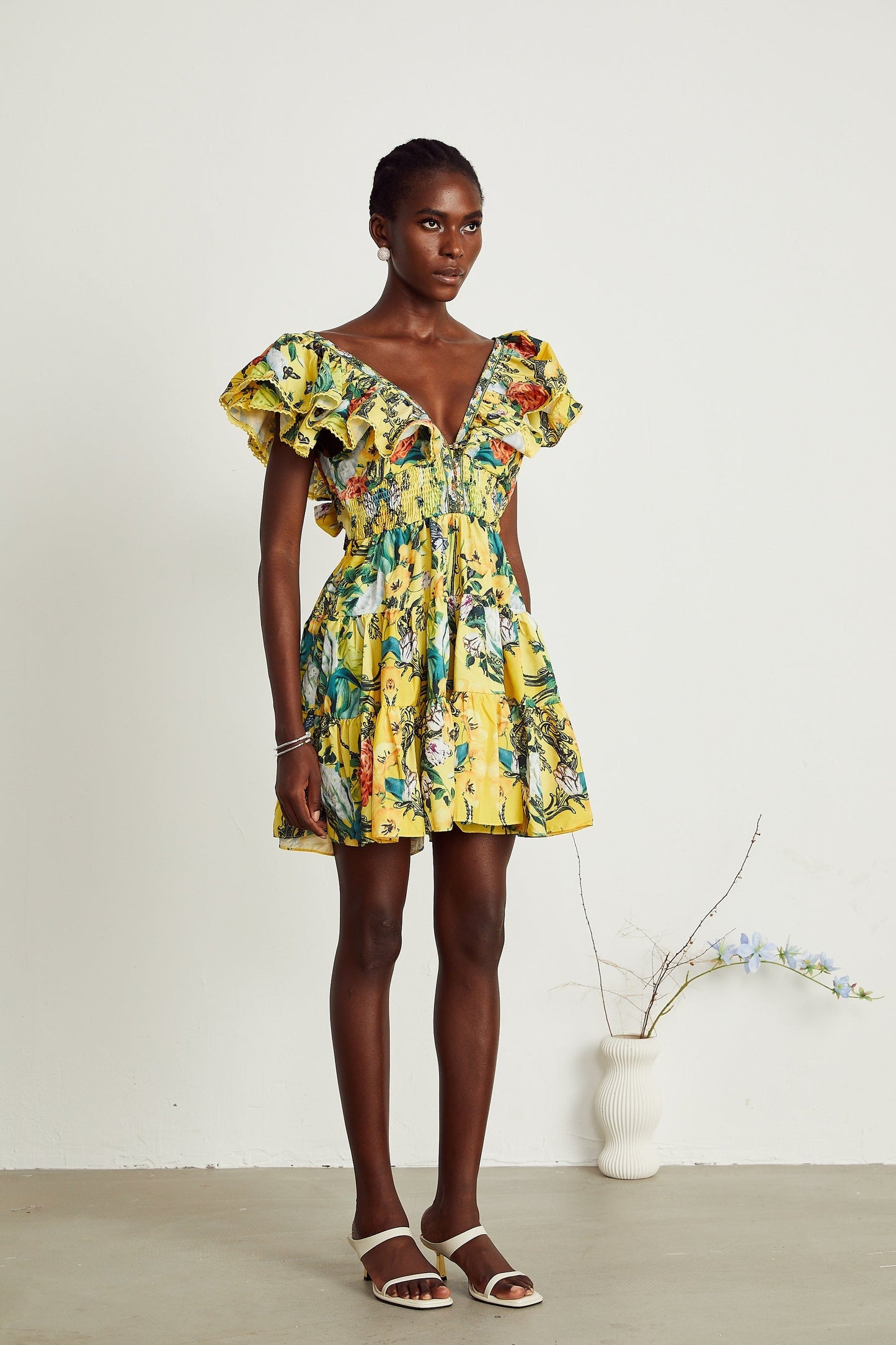 A yellow mini dress with ruffles and a floral print pattern