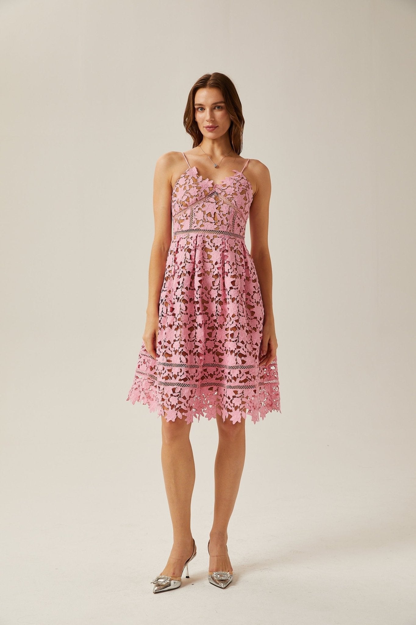 A modern midi dress crafted with intricate lace and cut-out designs