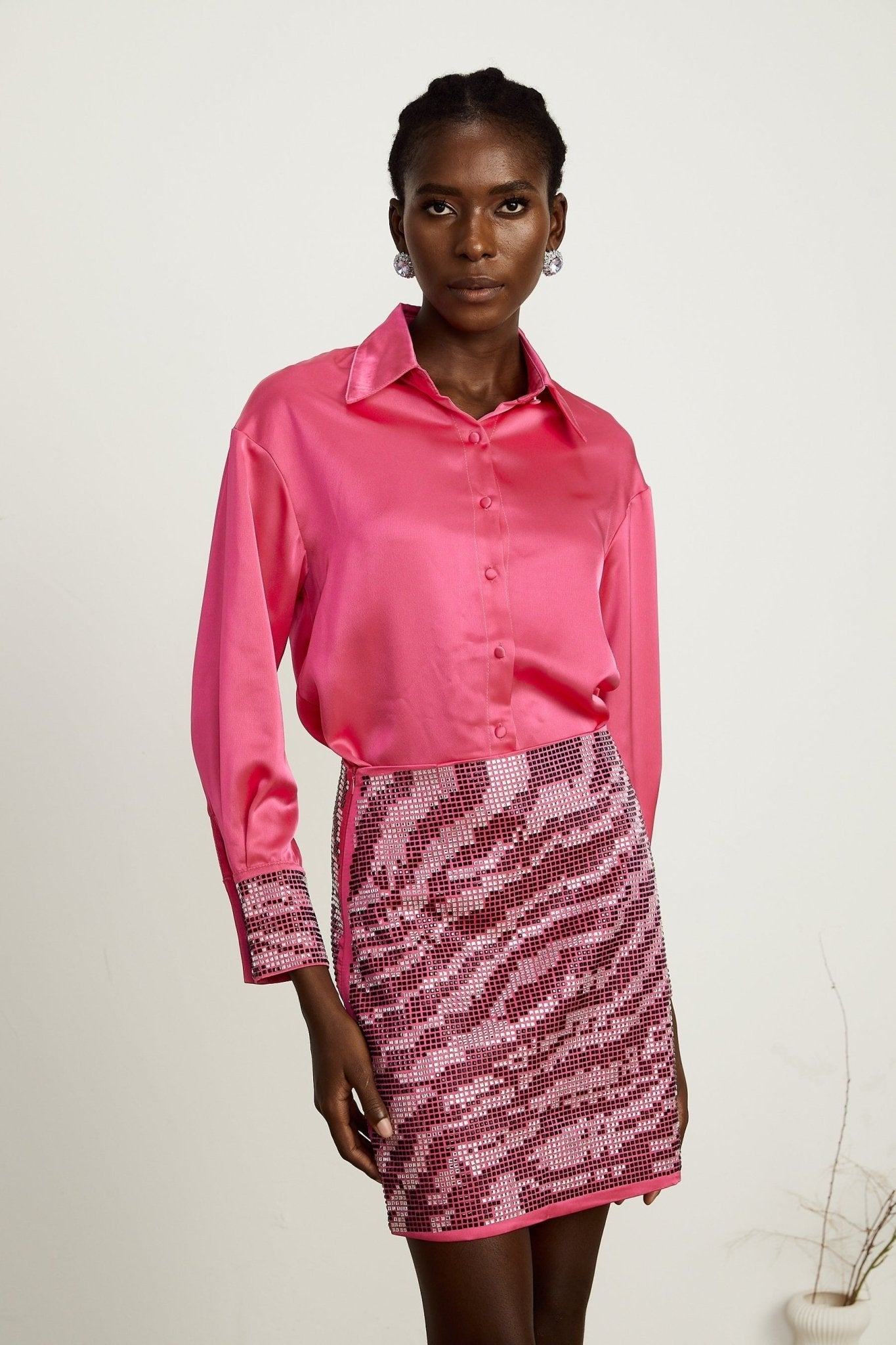 A graceful matching set featuring a satin shirt and skirt with intricate beading