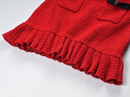 Striking red knitted wool jacket with black trim and decorative bows paired with a matching skirt featuring a flared hem