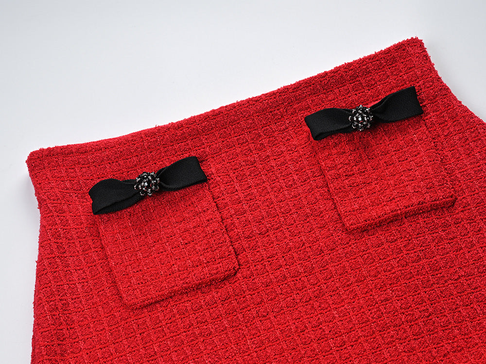 Striking red knitted wool jacket with black trim and decorative bows paired with a matching skirt featuring a flared hem