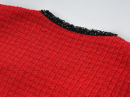 Striking red knitted wool jacket with black trim and decorative bows paired with a matching skirt featuring a flared hem