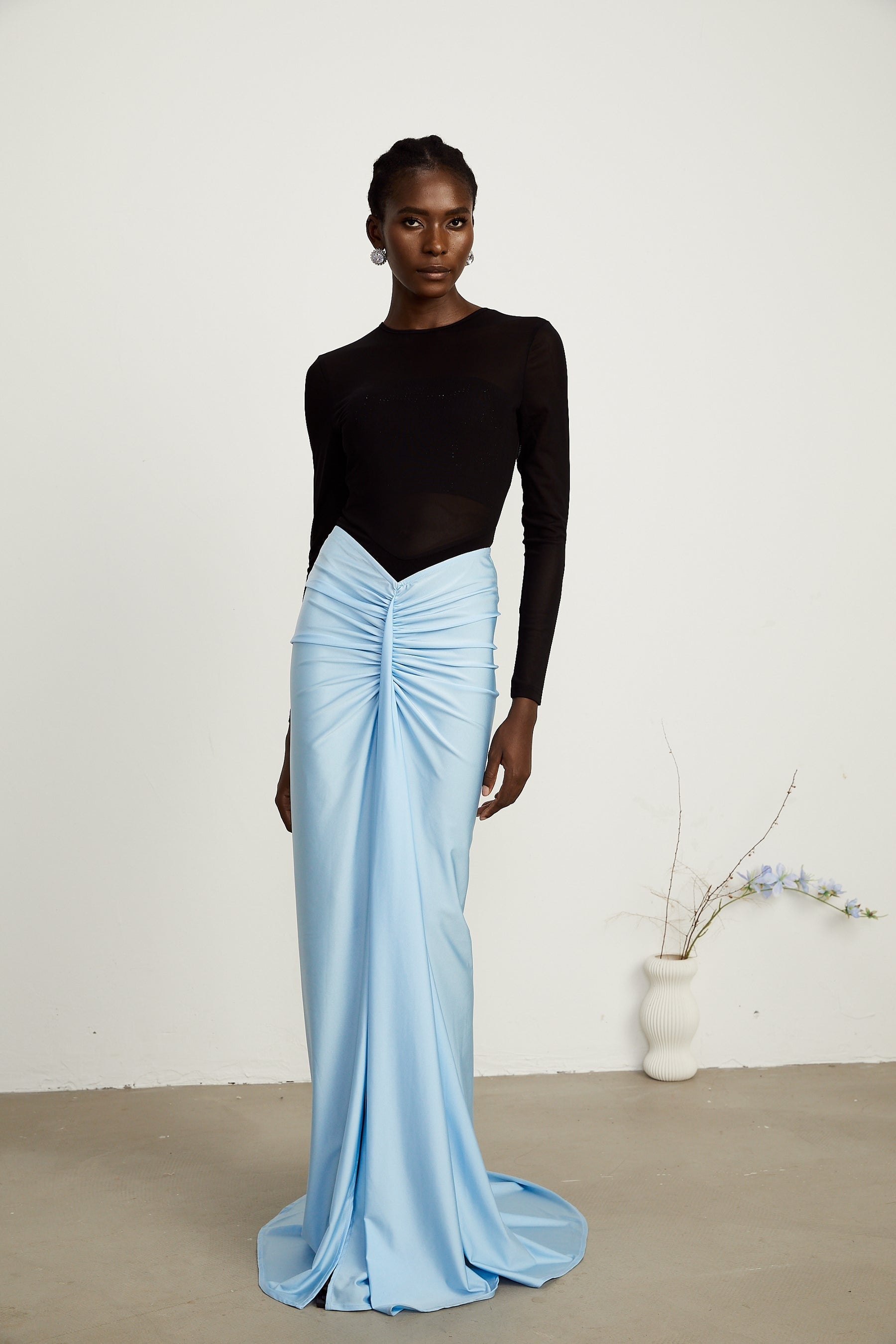 white bodysuit with colorful train design paired with a matching blue skirt