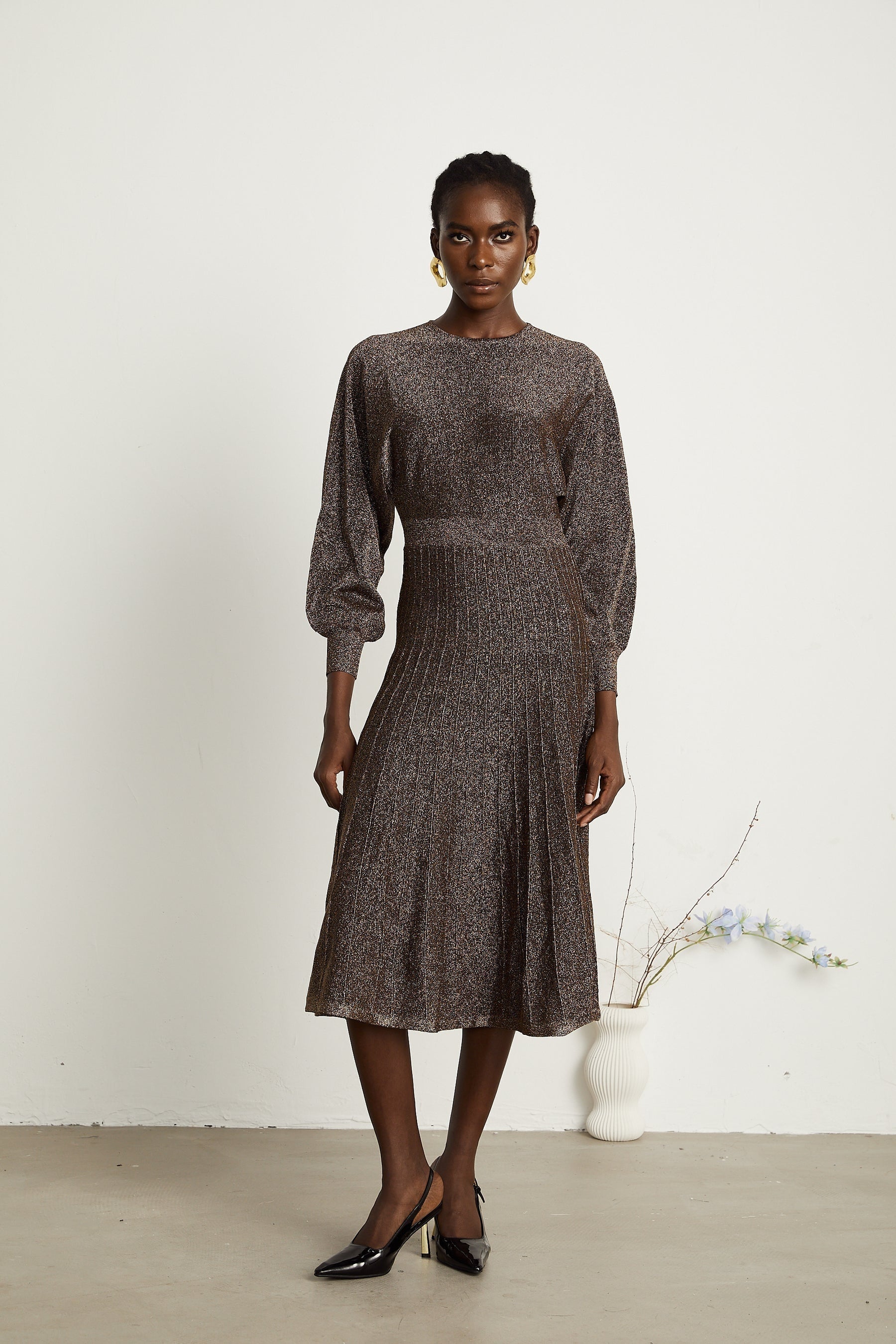 A brown ribbed midi dress with metallic threading and a fitted silhouette