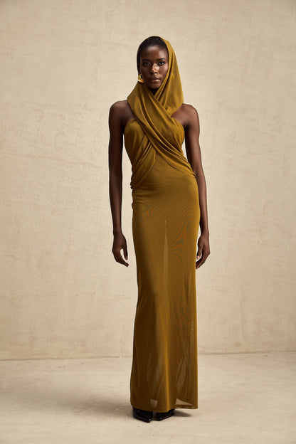 Woman wearing a long flowing maxi dress with a hood and crossover design featuring an open back