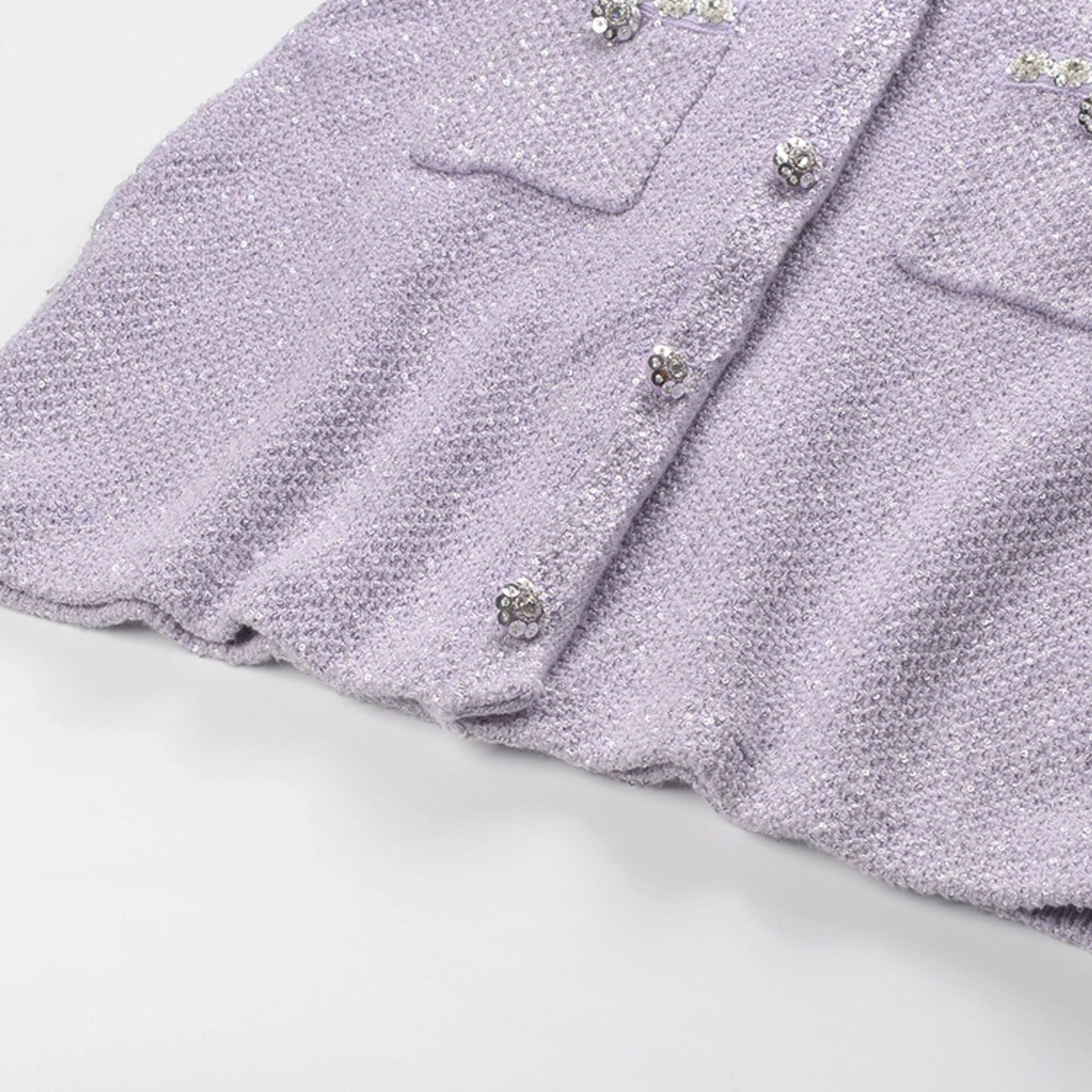 Lavender tweed dress with sequins faux pearl accents front pockets and button closure Thigh length Made of 80% Polyester 20% Cotton