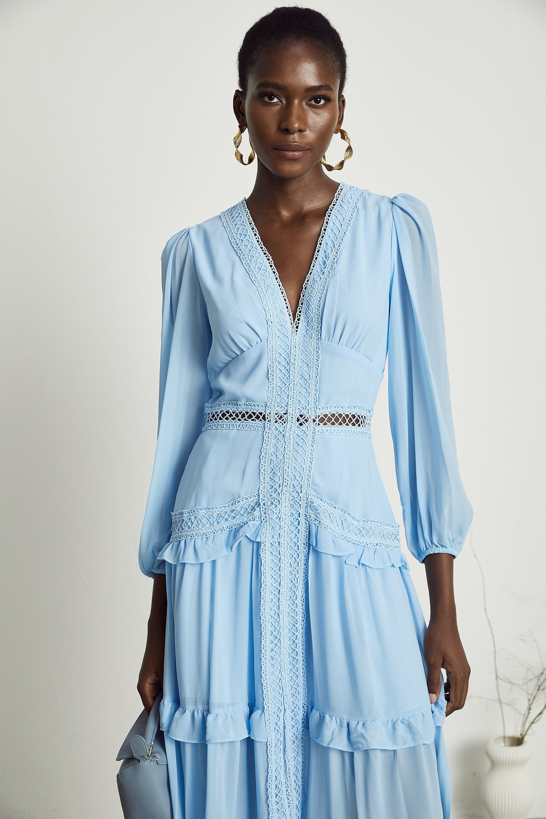 A blue maxi dress with ruffles and cutout details featuring a long flowing skirt and feminine silhouette