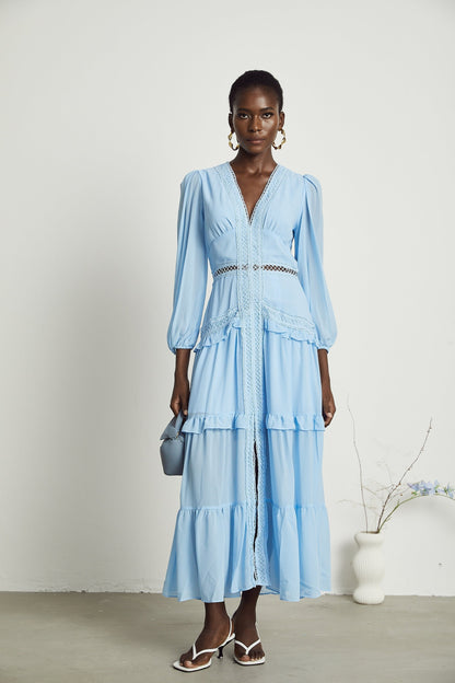 A blue maxi dress with ruffles and cutout details featuring a long flowing skirt and feminine silhouette