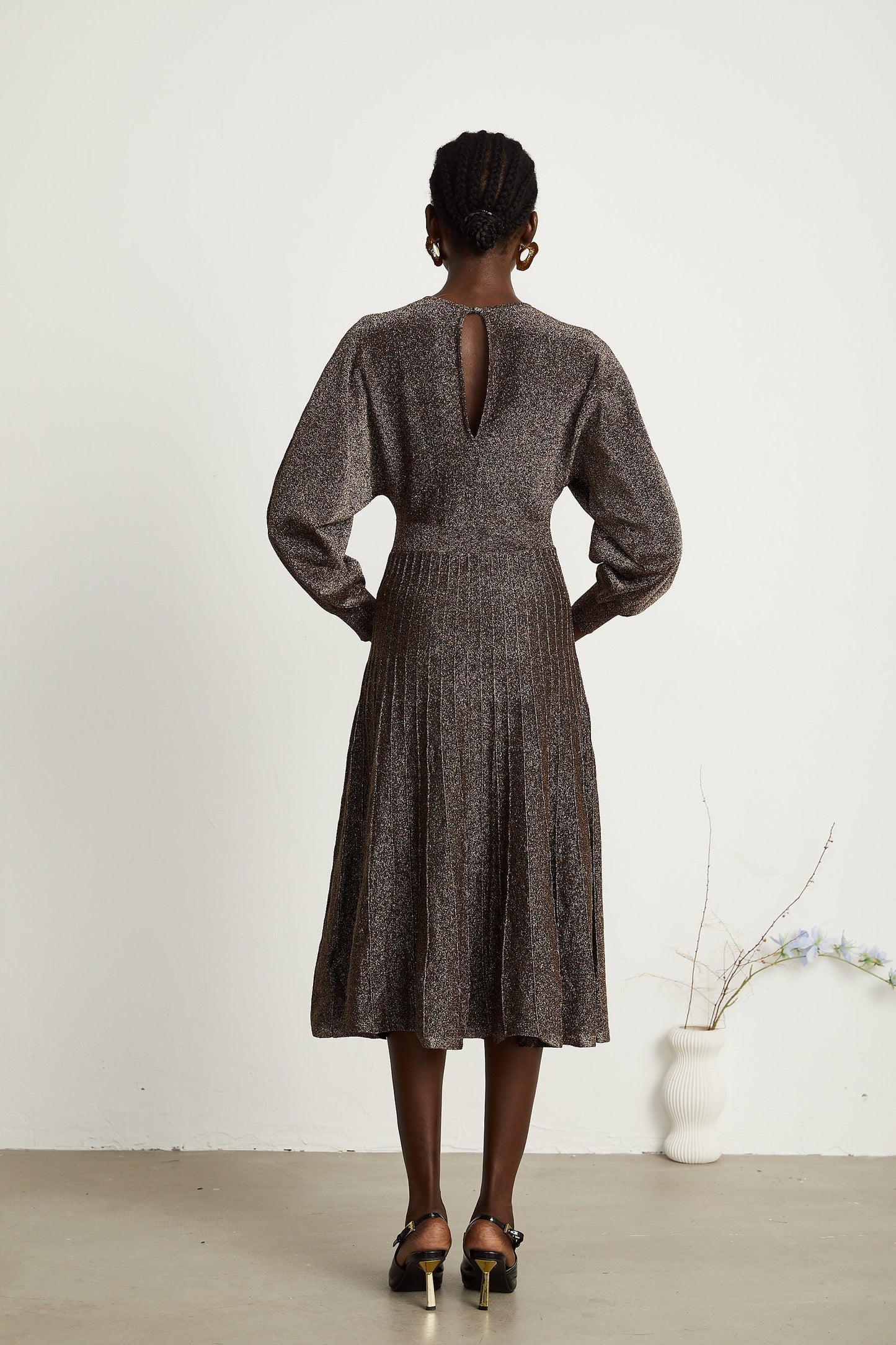 A brown ribbed midi dress with metallic threading and a fitted silhouette