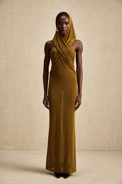 Woman wearing long flowing maxi dress with hood and open back design in crossover style