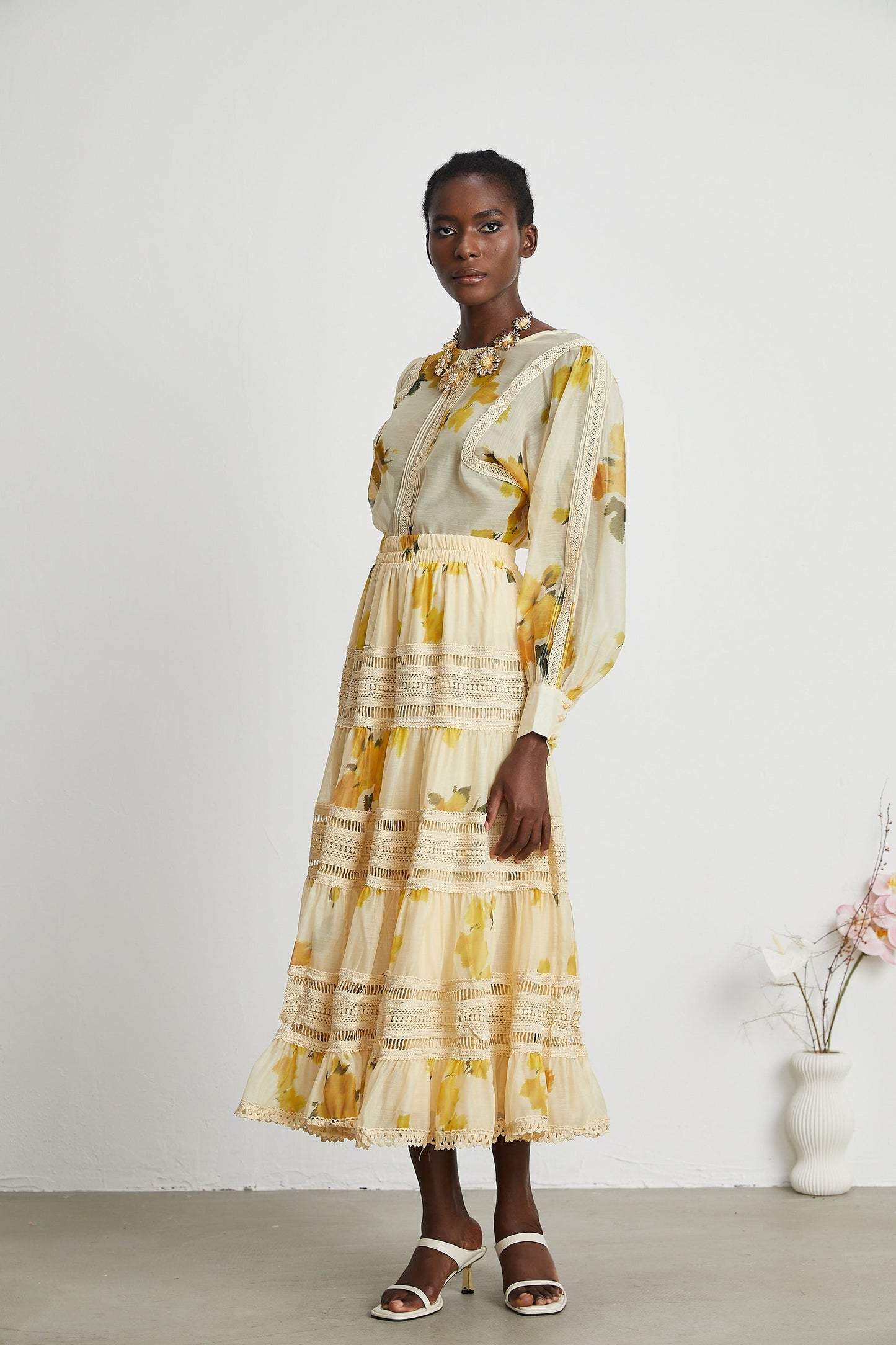 African woman wearing yellow floral print lace trim dress