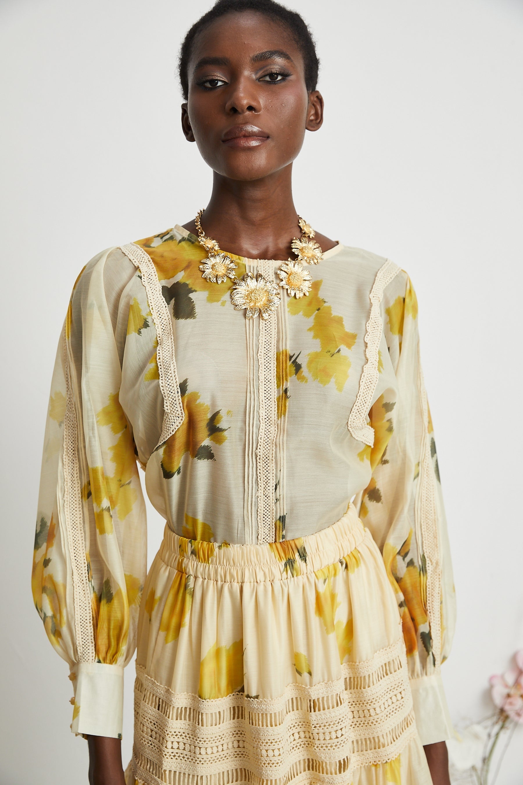 African woman wearing yellow floral blouse and skirt