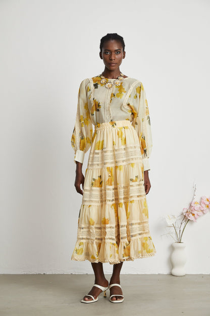 African woman wearing yellow floral lace dress and white sandals